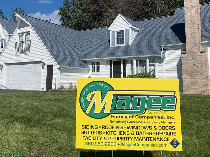 A home with a Magee Roofing & Remodeling sign in the front lawn