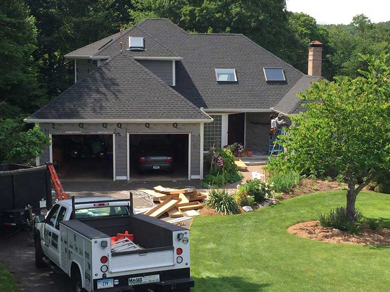 Overview of Magee Roofing & Remodeling working on installing new siding on a home